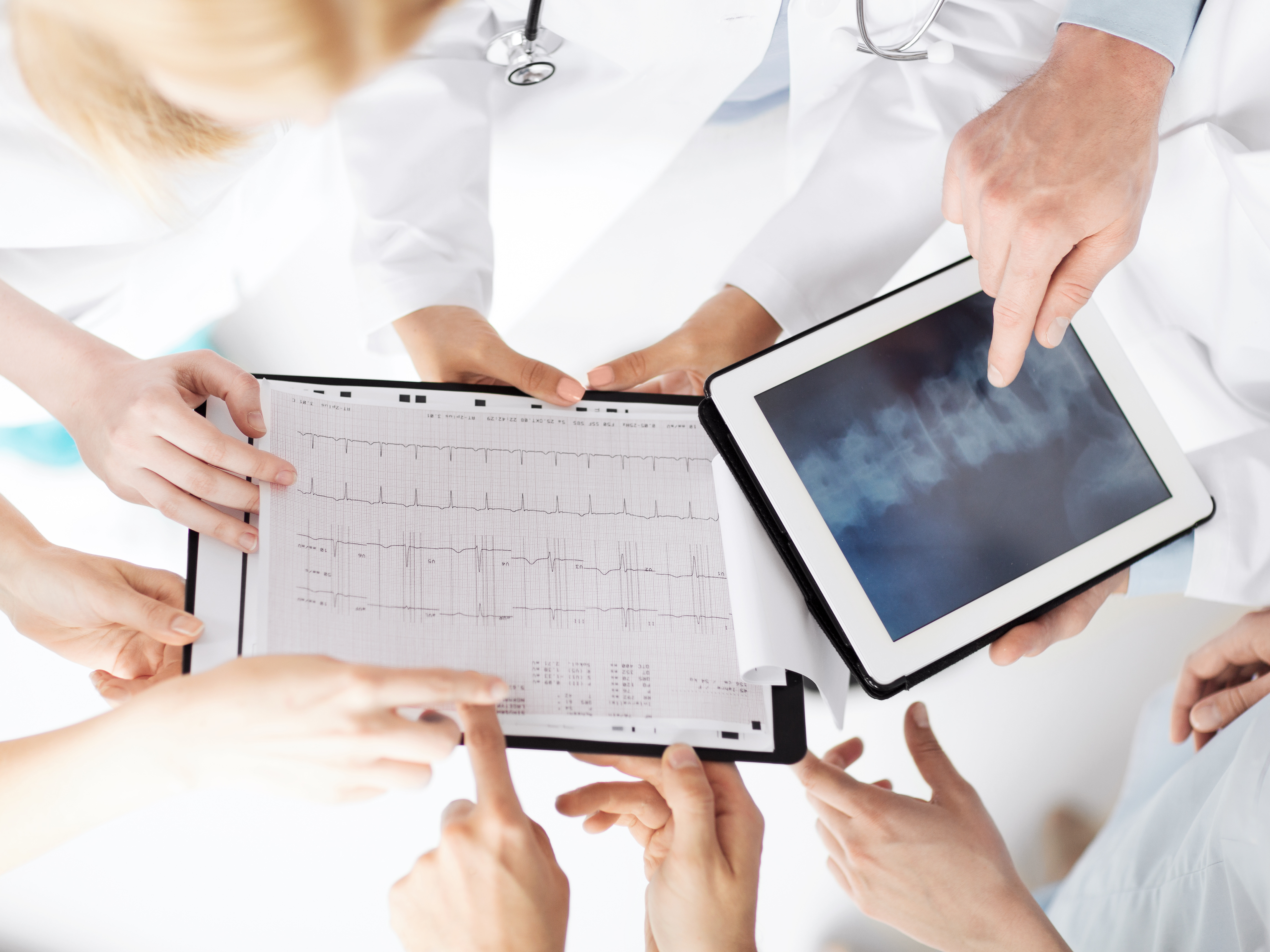 healthcare, hospital and medical concept - group of doctors looking at x-ray on tablet pc